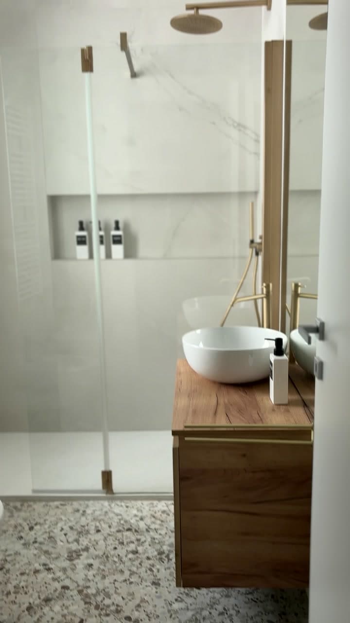 Bagno contemporaneo con mobile in legno e finiture ottone
